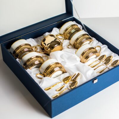 front view designed cutlery white gold colored glasses cups spoons inside blue box white background 140725 15924